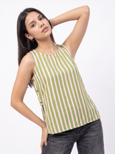 A woman modeling a sleeveless top with vertical olive green and cream stripes, paired with dark gray jeans, against a plain white studio background.