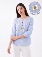 Add a fresh and feminine touch to your everyday wardrobe with this sky blue top, featuring delicate white daisy embroidery with mustard centres scattered across the front, a subtle split neckline, and contrast button detailing