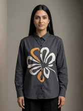 A contemporary charcoal grey shirt top featuring a bold white and mustard abstract floral graphic for a striking modern look.