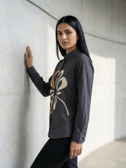 A contemporary charcoal grey shirt top featuring a bold white and mustard abstract floral graphic for a striking modern look.