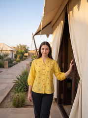 Bright and cheerful, this sunshine yellow top features delicate olive bow-motif embroidery scattered across the front. The split neckline, button-front detailing, and 3/4 gathered sleeves create a neat yet relaxed look.