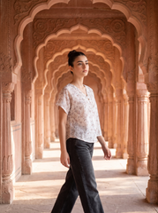 A soft off-white top featuring delicate grey and beige botanical leaf motifs for an elegant, understated look.