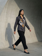 A contemporary charcoal grey shirt top featuring a bold white and mustard abstract floral graphic for a striking modern look.