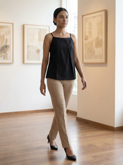A sleek black sleeveless top designed with slim shoulder straps and subtle front pleat detailing for a clean, contemporary look.