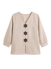 A beige linen long-sleeve blouse with a V-neckline and three black flower-shaped buttons down the front, displayed on a clean white background.