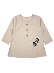 A beige linen long-sleeve tunic top with a three-button henley neckline and black embroidered leaf motifs on the lower right side, displayed flat against a white background.