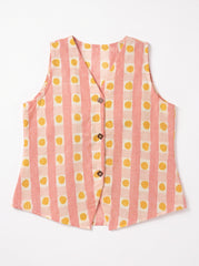 A sleeveless vest with vertical pink and white stripes and yellow polka dots, featuring a V-neck and three brown buttons down the front, laid flat on a white background.