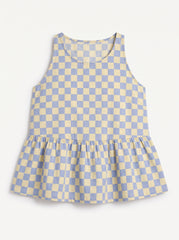 A sleeveless children's top with a light blue and cream checkerboard pattern and a gathered ruffle hem, shown flat against a light background.