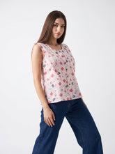 A soft light pink sleeveless top featuring delicate pink florals with navy and subtle botanical accents for a fresh feminine look.