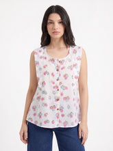 A fresh off-white sleeveless top featuring delicate pink and blue floral clusters for a soft feminine look.