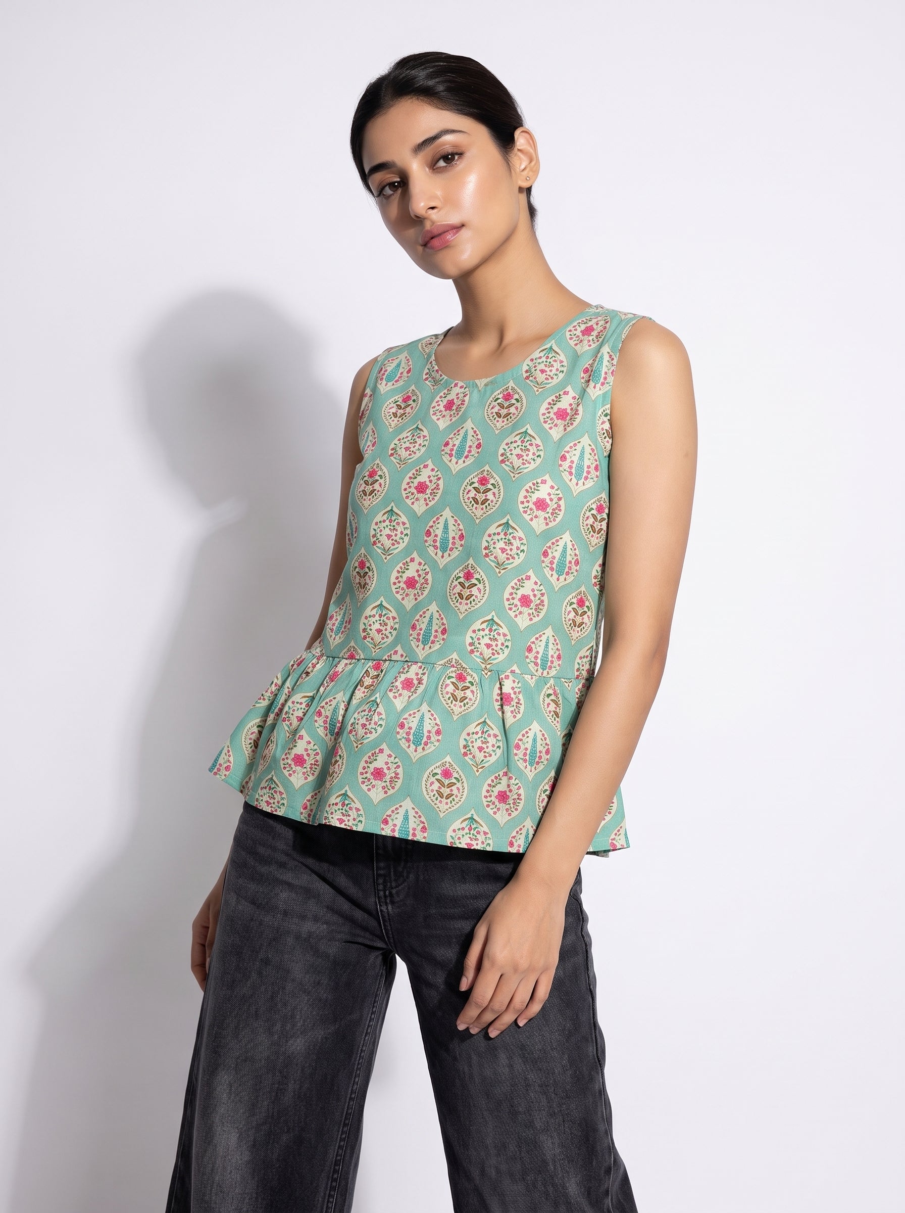 A stylish mint green sleeveless top featuring an elegant ethnic-inspired teardrop motif print all over.