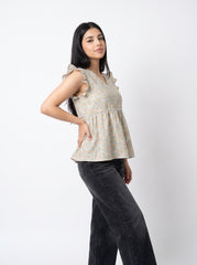 A soft off-white top featuring delicate peach and muted blue floral motifs for a fresh, feminine look.