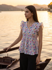 A fresh off-white top featuring soft pink, blue, peach, and green floral motifs for a bright feminine look.
