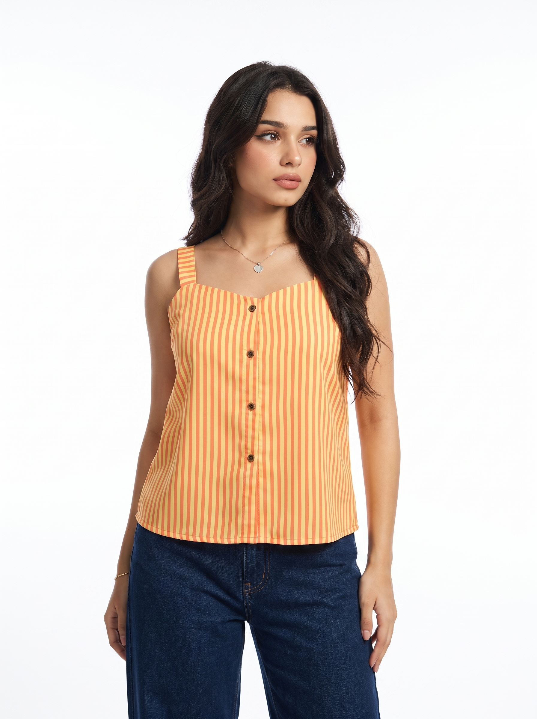A woman modeling a sleeveless orange and yellow vertically striped top with a button-down front, paired with dark blue jeans, against a plain white studio background.