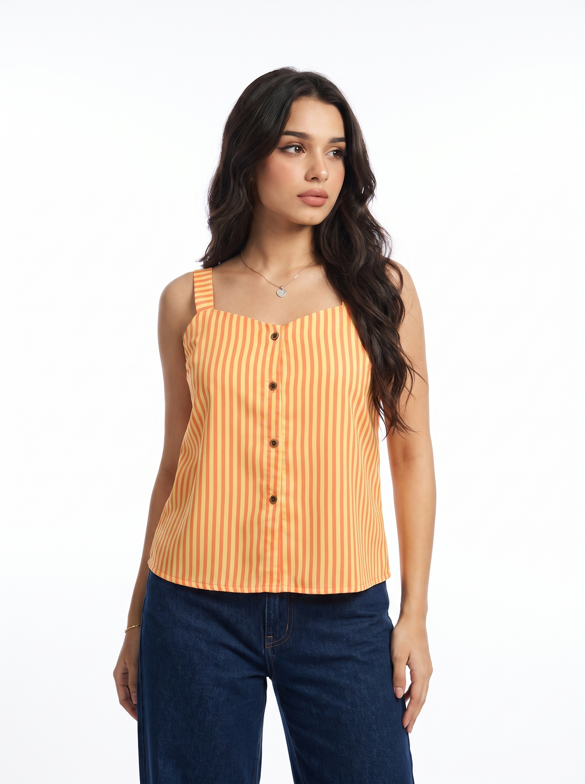 A woman modeling a sleeveless orange and yellow vertically striped top with a button-down front, paired with dark blue jeans, against a plain white studio background.