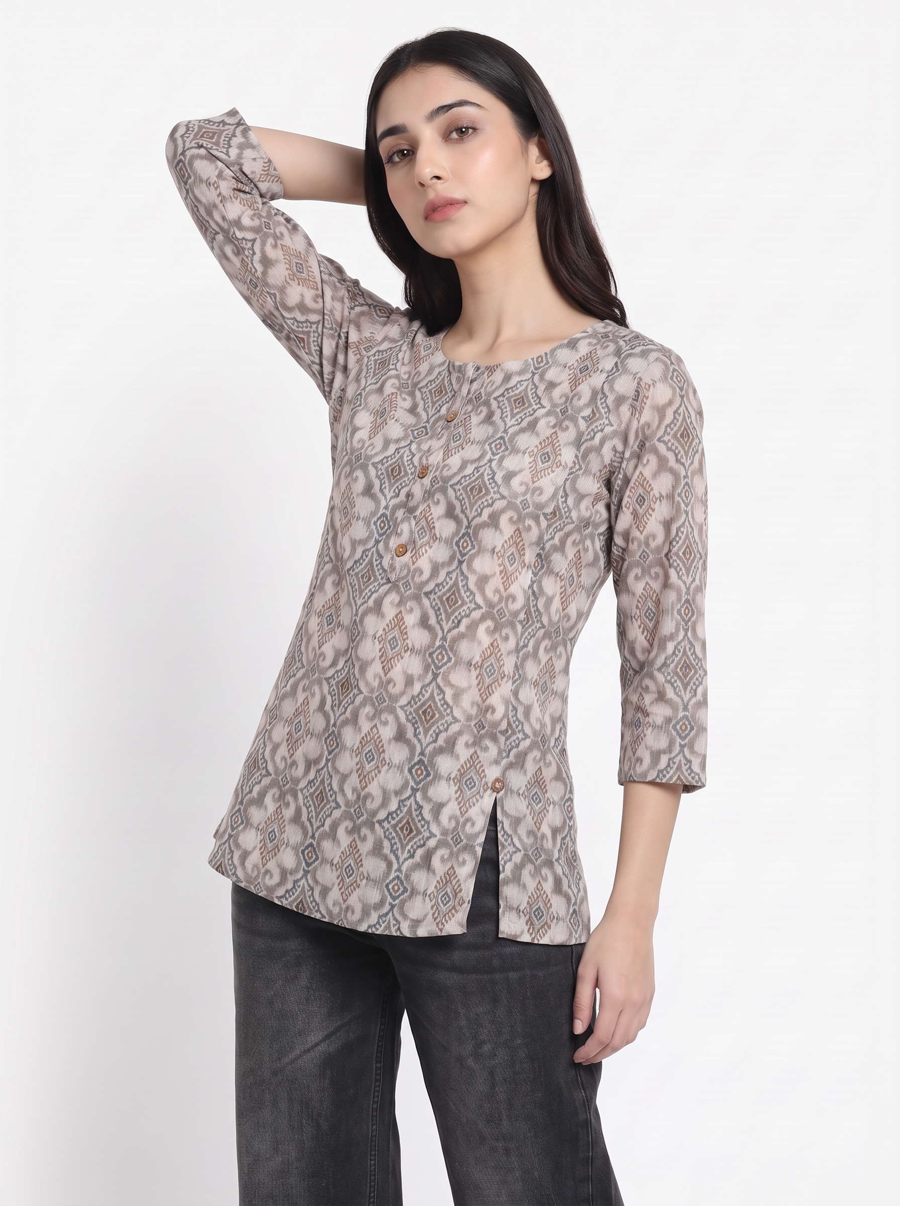 A woman modeling a three-quarter sleeve top with a beige, brown, and gray snake print pattern, paired with dark gray jeans, against a plain white background.