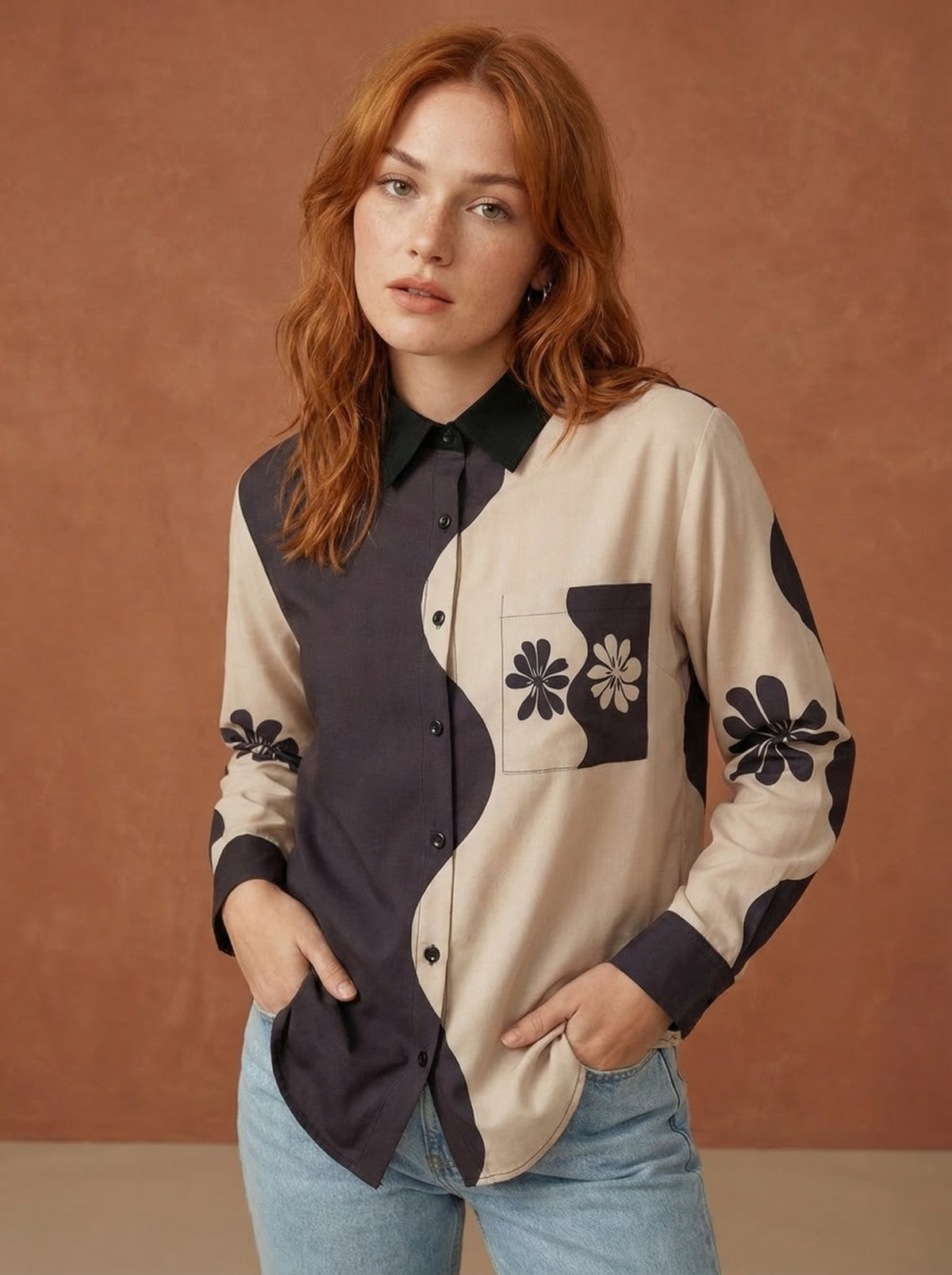 A contemporary beige and black shirt top featuring a striking asymmetric colorblock design with bold floral graphics for a distinctive modern look