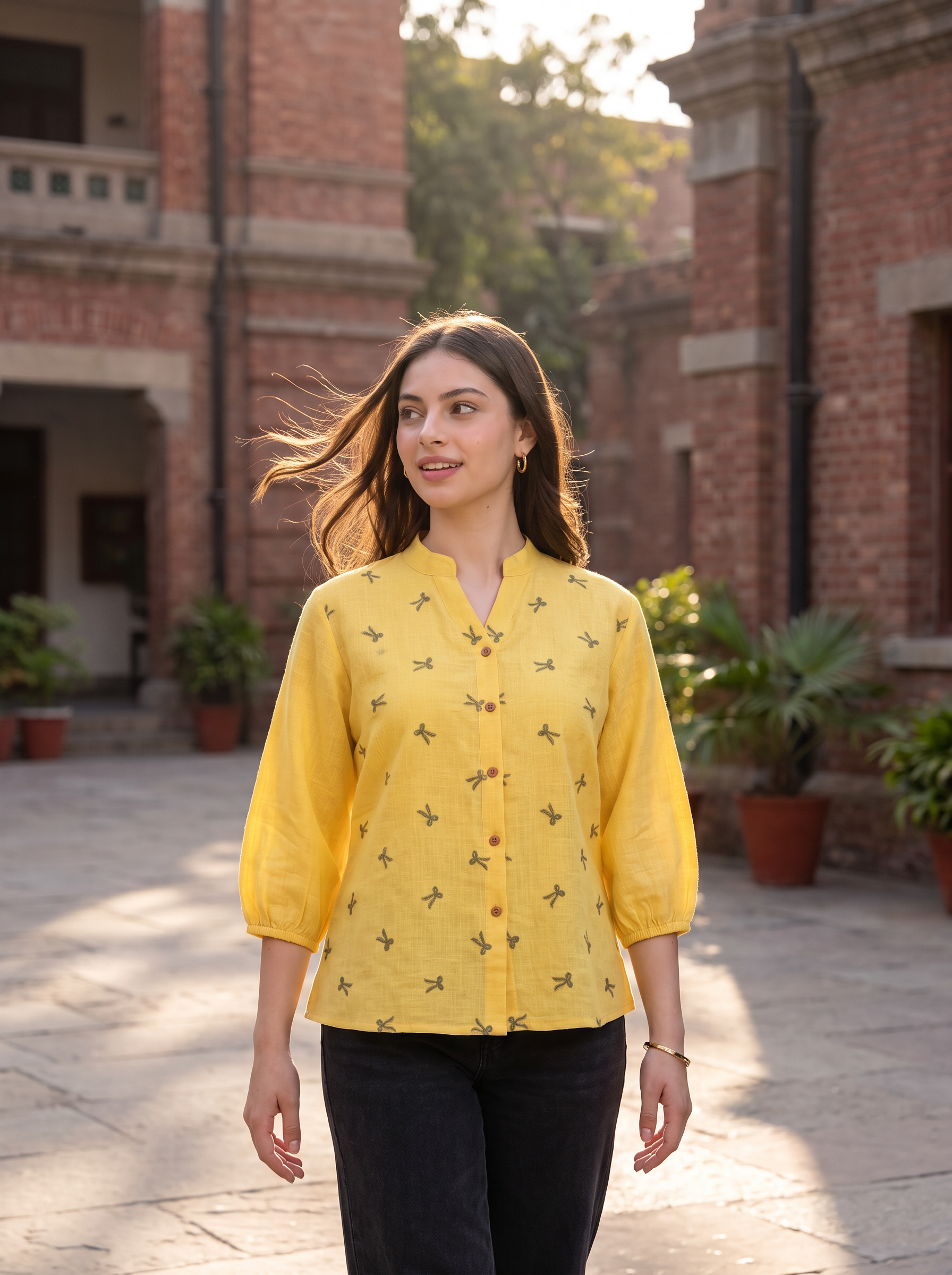 Bright and cheerful, this sunshine yellow top features delicate olive bow-motif embroidery scattered across the front. The split neckline, button-front detailing, and 3/4 gathered sleeves create a neat yet relaxed look.