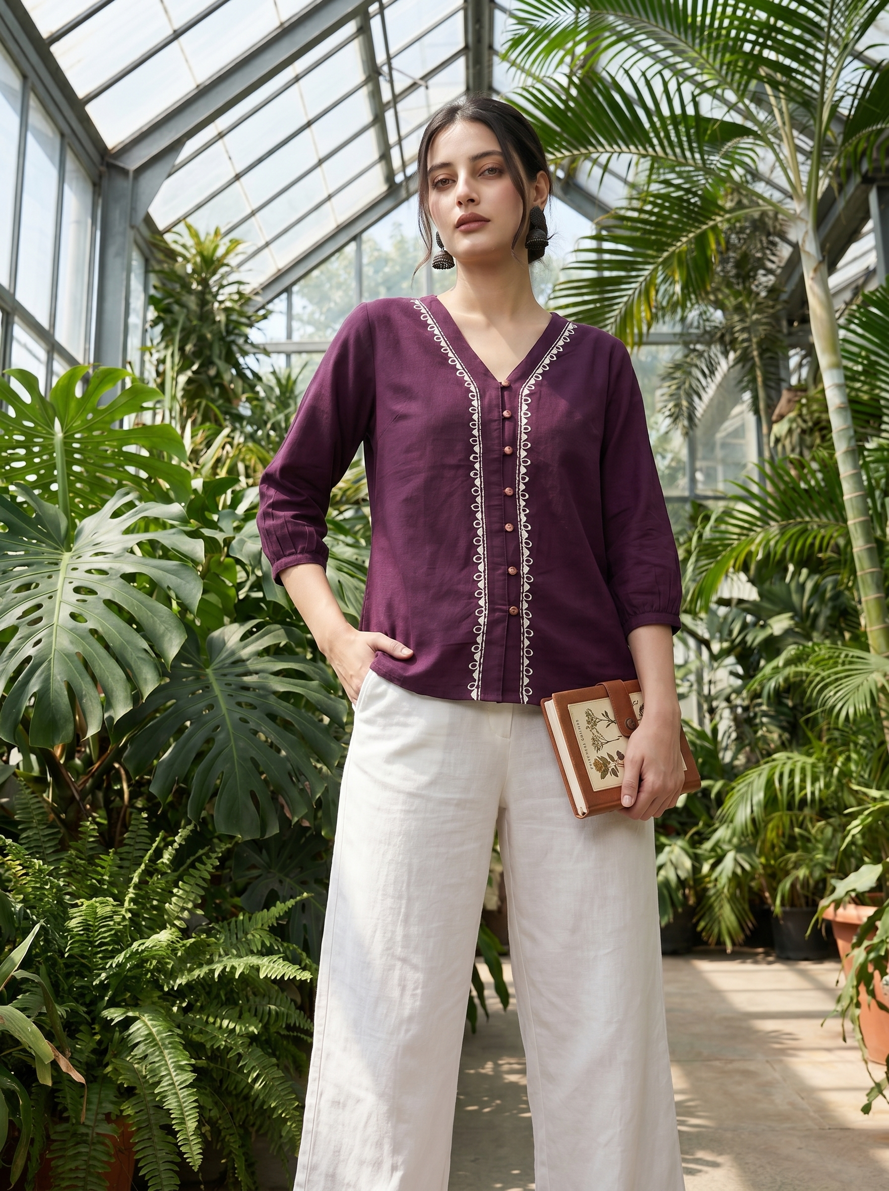 A rich plum purple top featuring elegant white contrast embroidery along the V-neckline and front placket for a refined statement look.