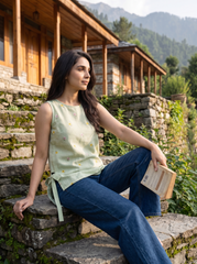 Add a soft feminine touch to your wardrobe with this sage green sleeveless top, featuring delicate multicolor floral embroidery scattered across the front, a clean round neckline, and stylish side tie-up detailing.