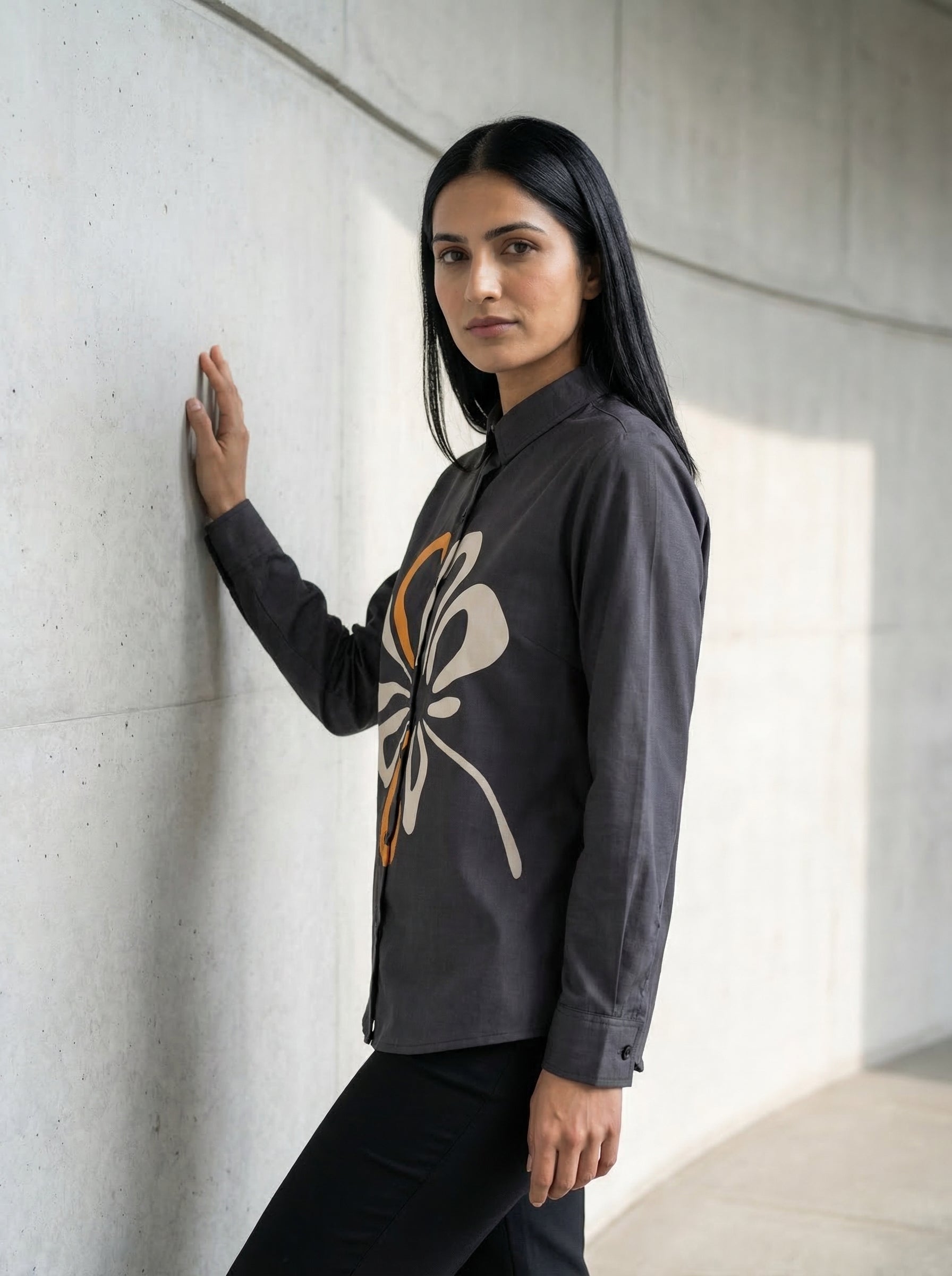 A contemporary charcoal grey shirt top featuring a bold white and mustard abstract floral graphic for a striking modern look. 