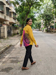 A striking mustard yellow shirt top featuring a bold contrast pink-purple panel at the back with an oversized black floral graphic for a statement finish.