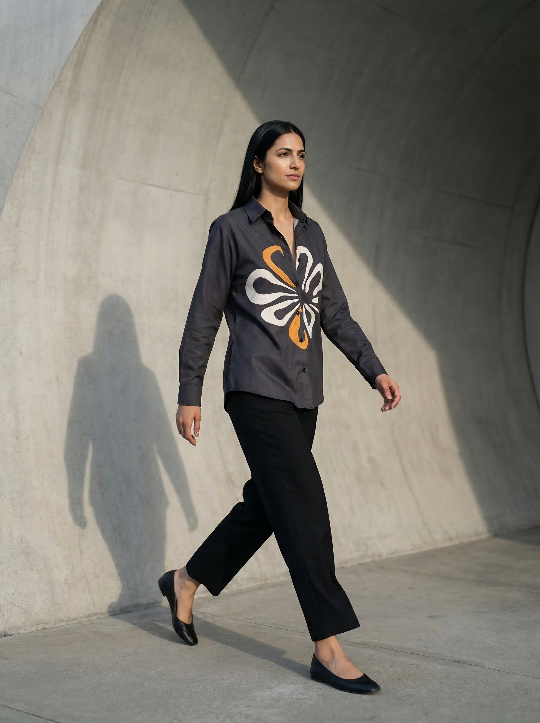 A contemporary charcoal grey shirt top featuring a bold white and mustard abstract floral graphic for a striking modern look. 