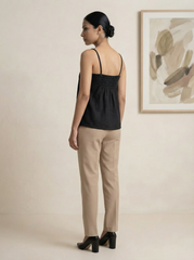 A sleek black sleeveless top designed with slim shoulder straps and subtle front pleat detailing for a clean, contemporary look.