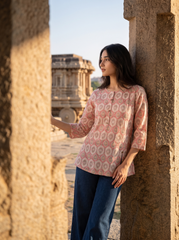 A stylish off-white top featuring soft pink ethnic-inspired motifs for a fresh everyday look