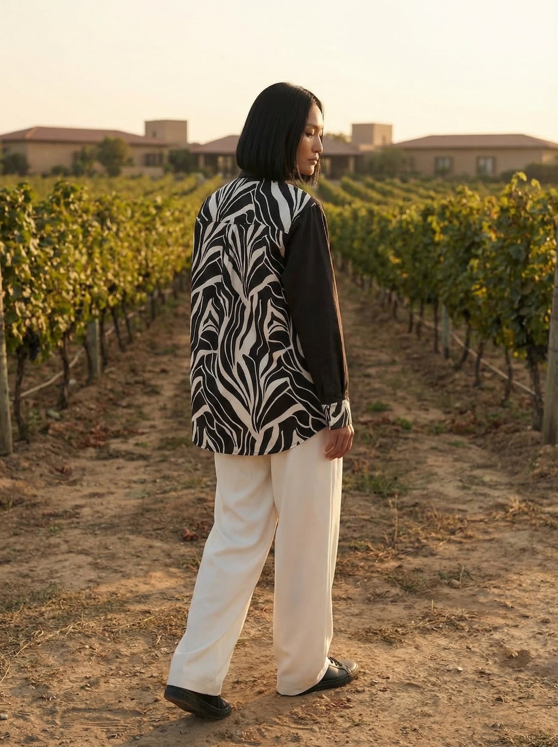 A contemporary beige and black shirt top featuring a striking asymmetric colorblock design with bold floral graphics for a distinctive modern look.