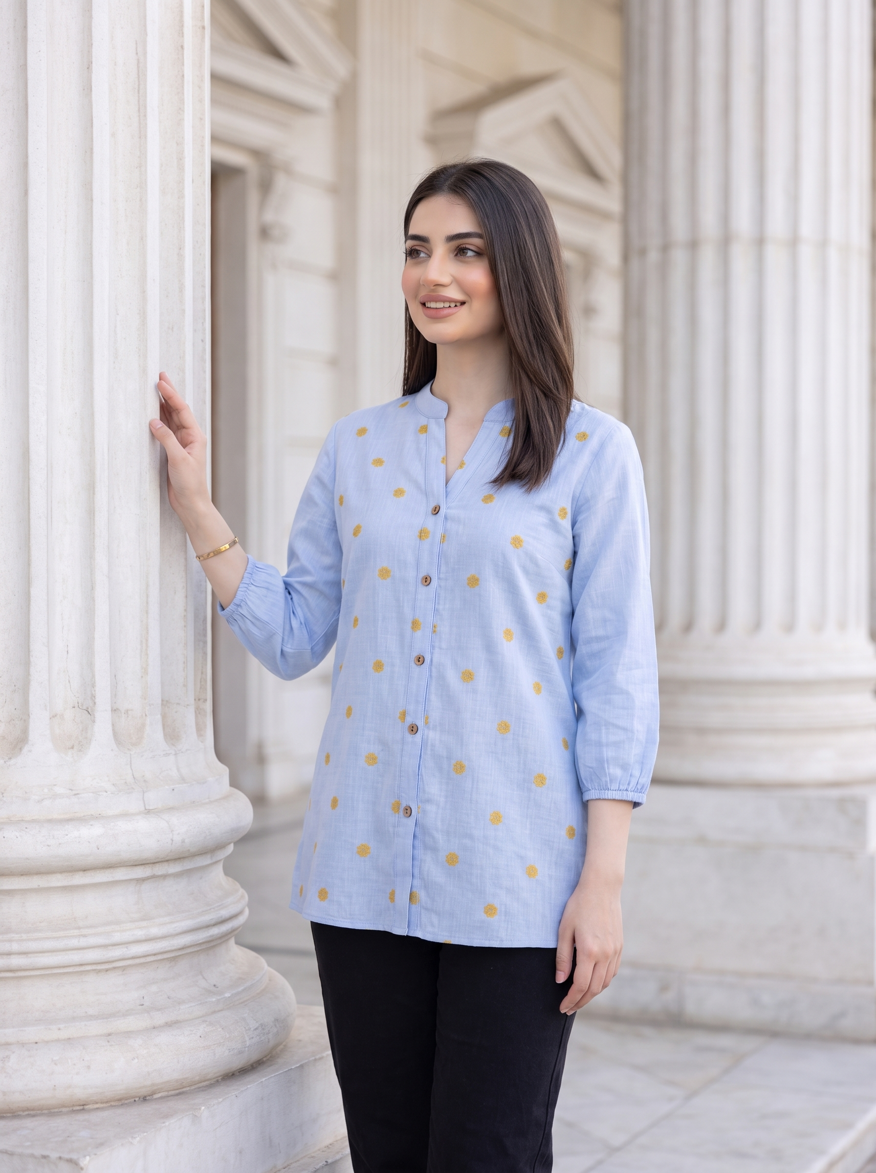 A fresh sky blue top featuring delicate mustard floral embroidery for a subtle contrast. The split neckline, front button detailing, and 3/4 gathered sleeves give it a polished yet easy look.