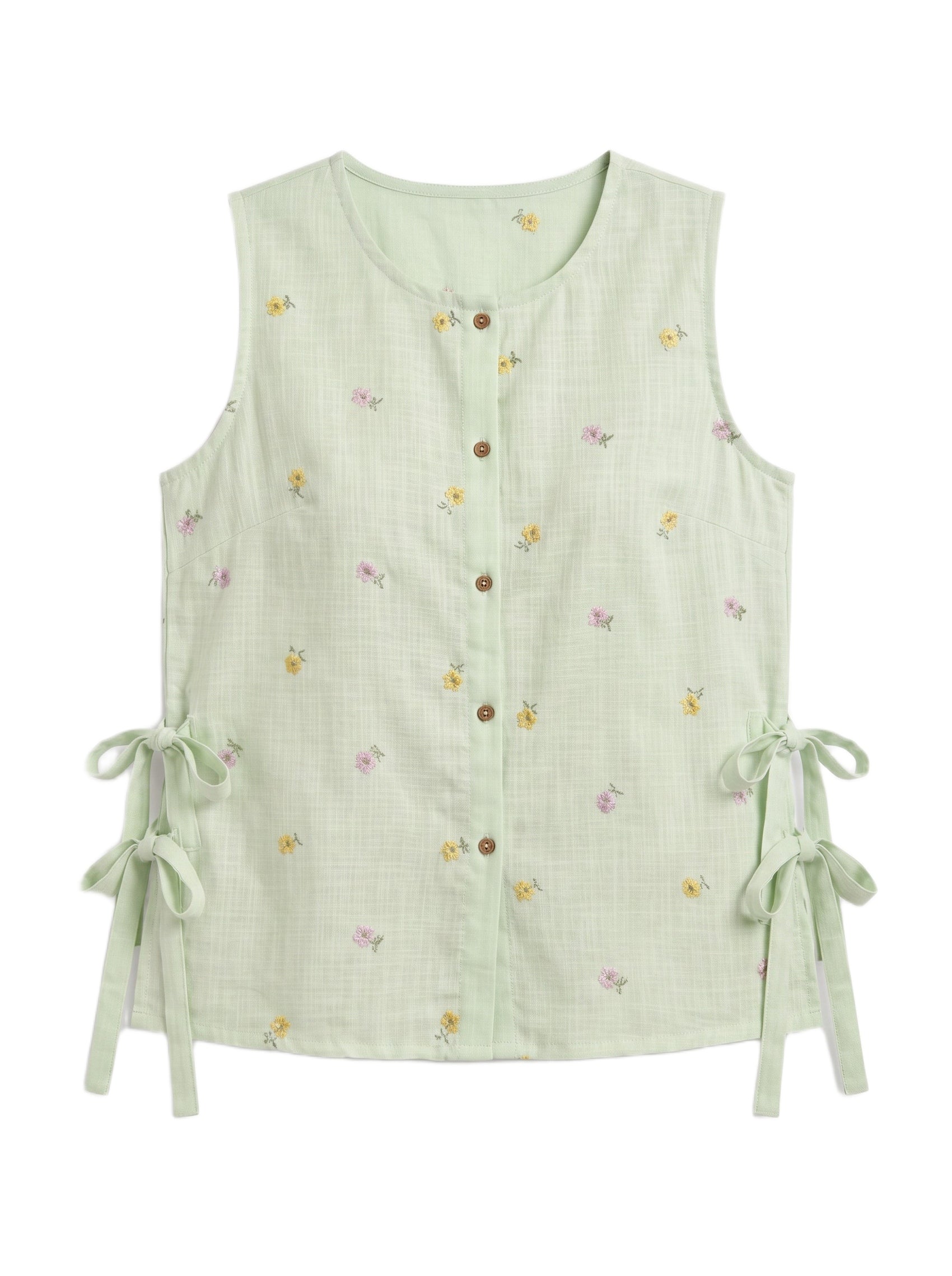 A sleeveless light green linen vest with a button-down front, tiny yellow and pink floral print, and side tie details, shown on a plain white background.