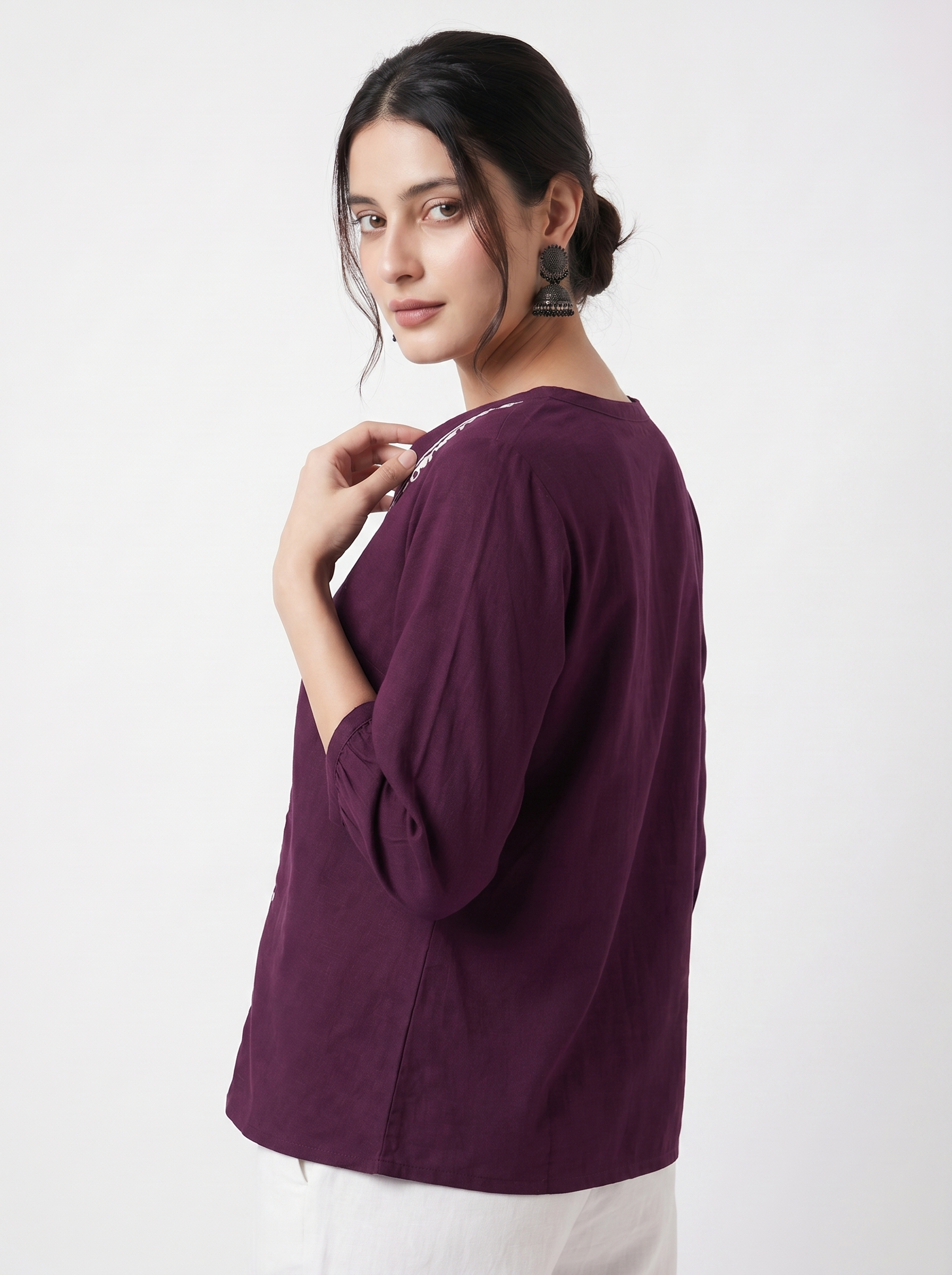A rich plum purple top featuring elegant white contrast embroidery along the V-neckline and front placket for a refined statement look.