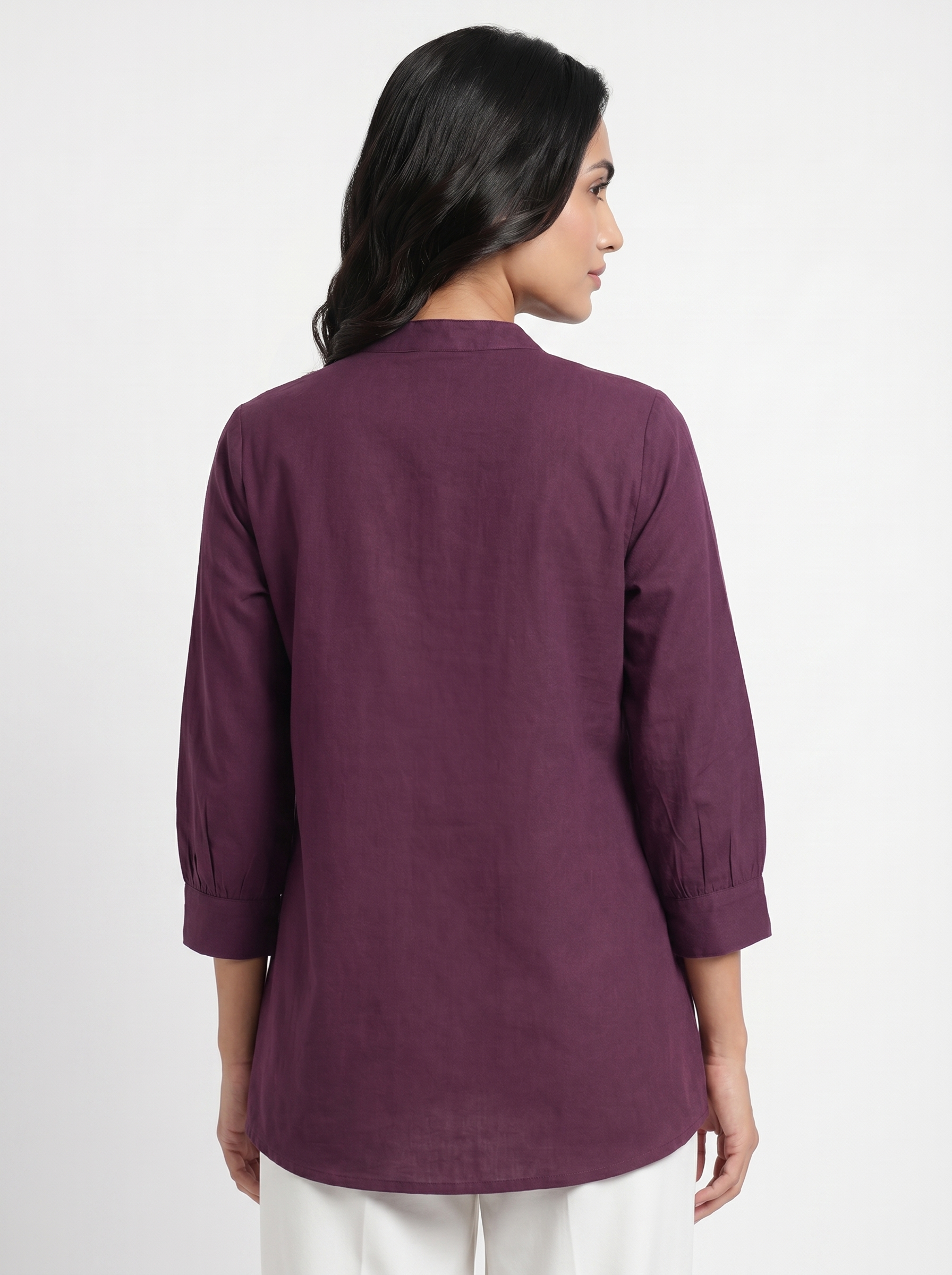 A graceful plum purple tunic top featuring delicate off-white floral vine embroidery around the neckline for an elegant handcrafted touch.