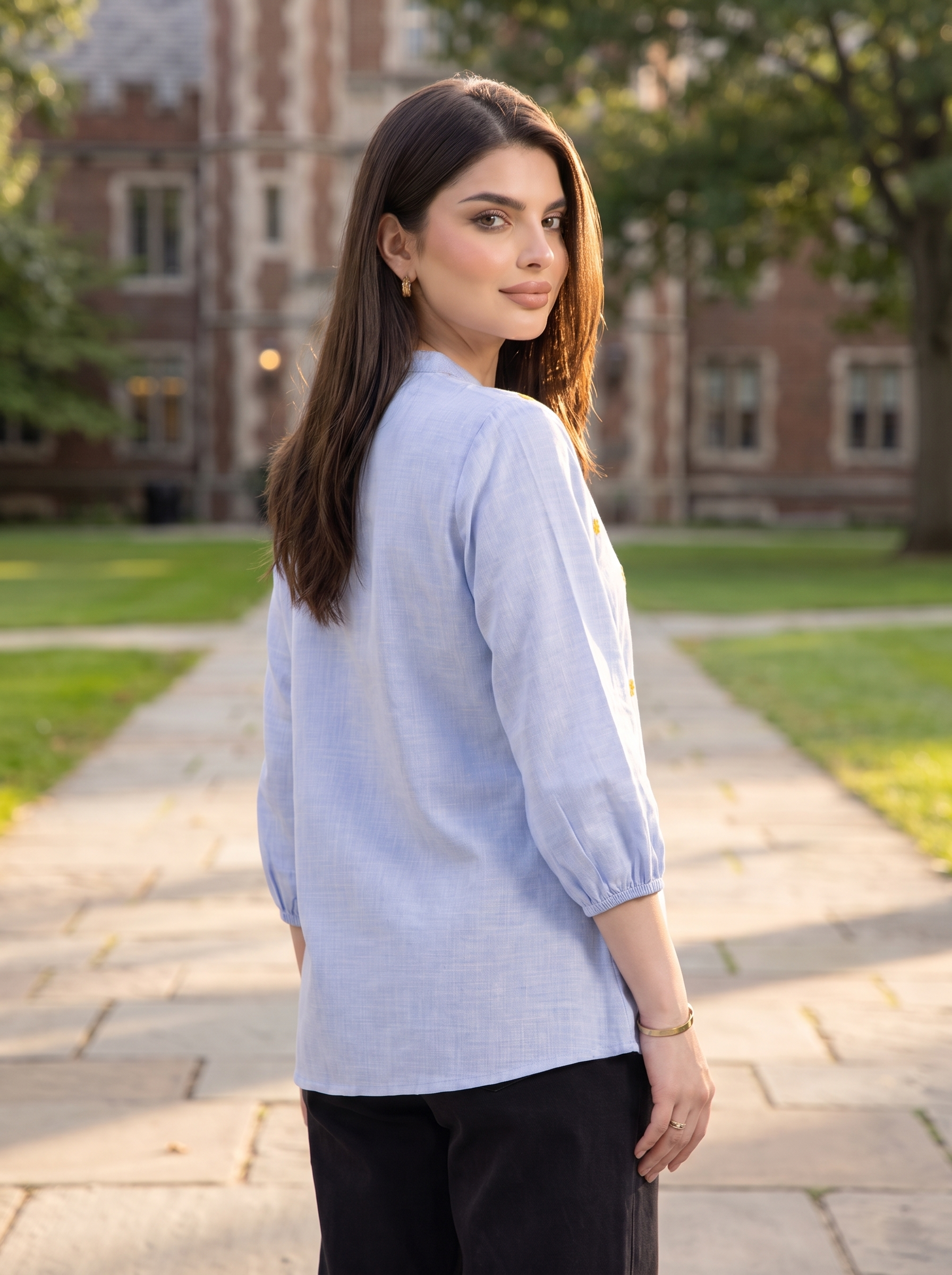 A fresh sky blue top featuring delicate mustard floral embroidery for a subtle contrast. The split neckline, front button detailing, and 3/4 gathered sleeves give it a polished yet easy look.