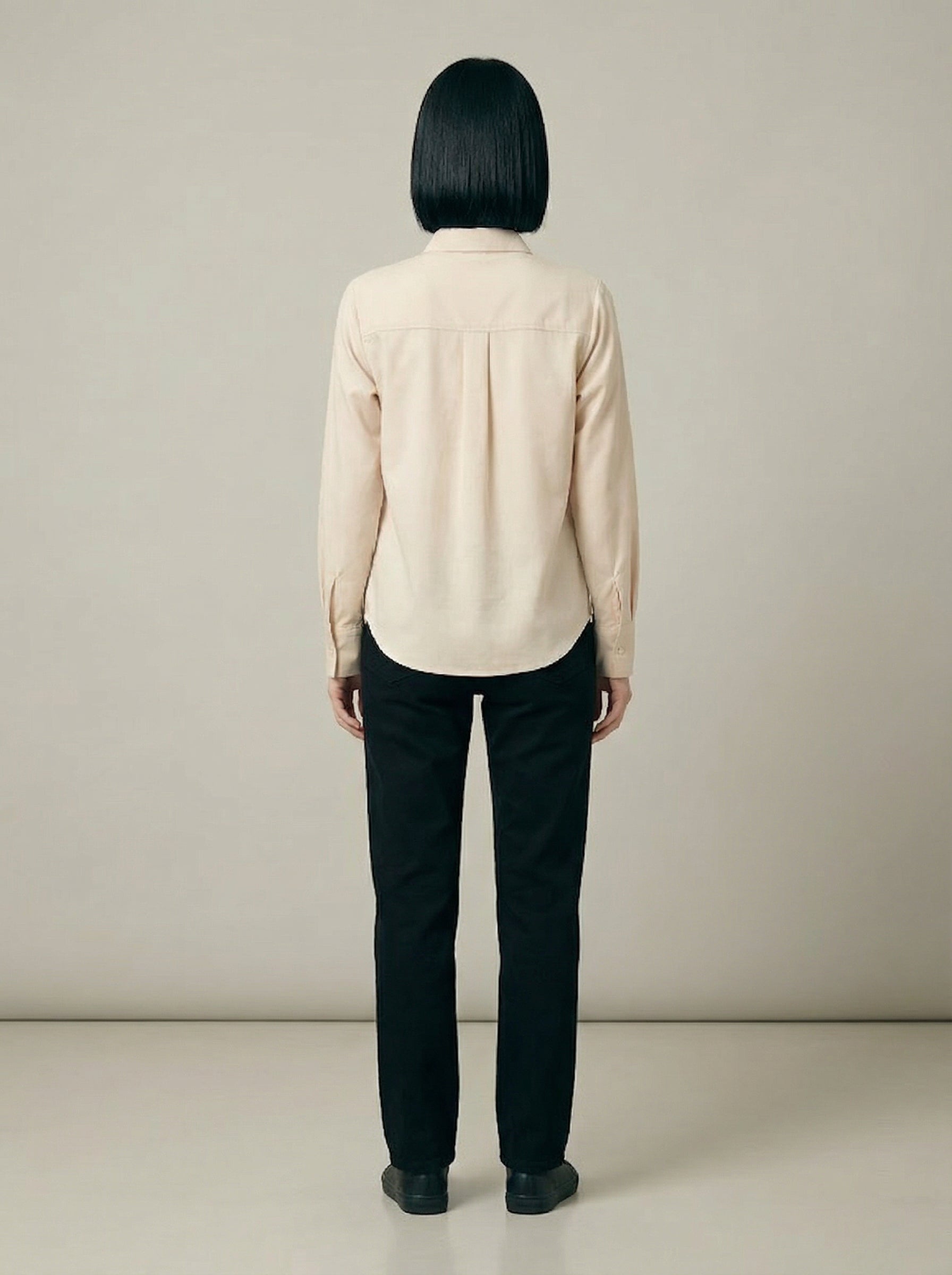 A contemporary cream shirt top featuring a bold black monstera leaf graphic on the front for a clean and artistic statement look. 