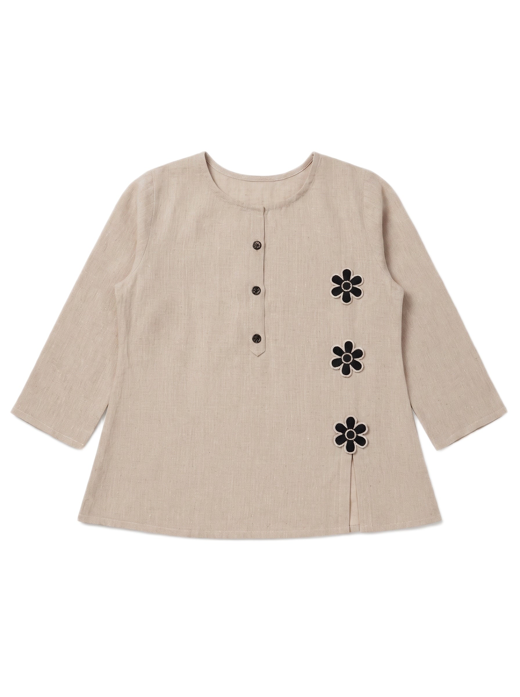 A beige linen long-sleeve top with a round neckline, three-quarter sleeves, a buttoned front placket, and three black embroidered flower motifs on the right side.