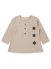 A beige linen long-sleeve top with a round neckline, three-quarter sleeves, a buttoned front placket, and three black embroidered flower motifs on the right side.