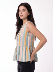 A woman modeling a sleeveless peplum top with vertical pastel stripes in blue, yellow, pink, and beige, paired with black pants against a plain white background.