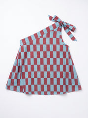 A one-shoulder dress featuring a red and light blue checkerboard pattern, with a tie detail at the shoulder, laid flat on a white background.