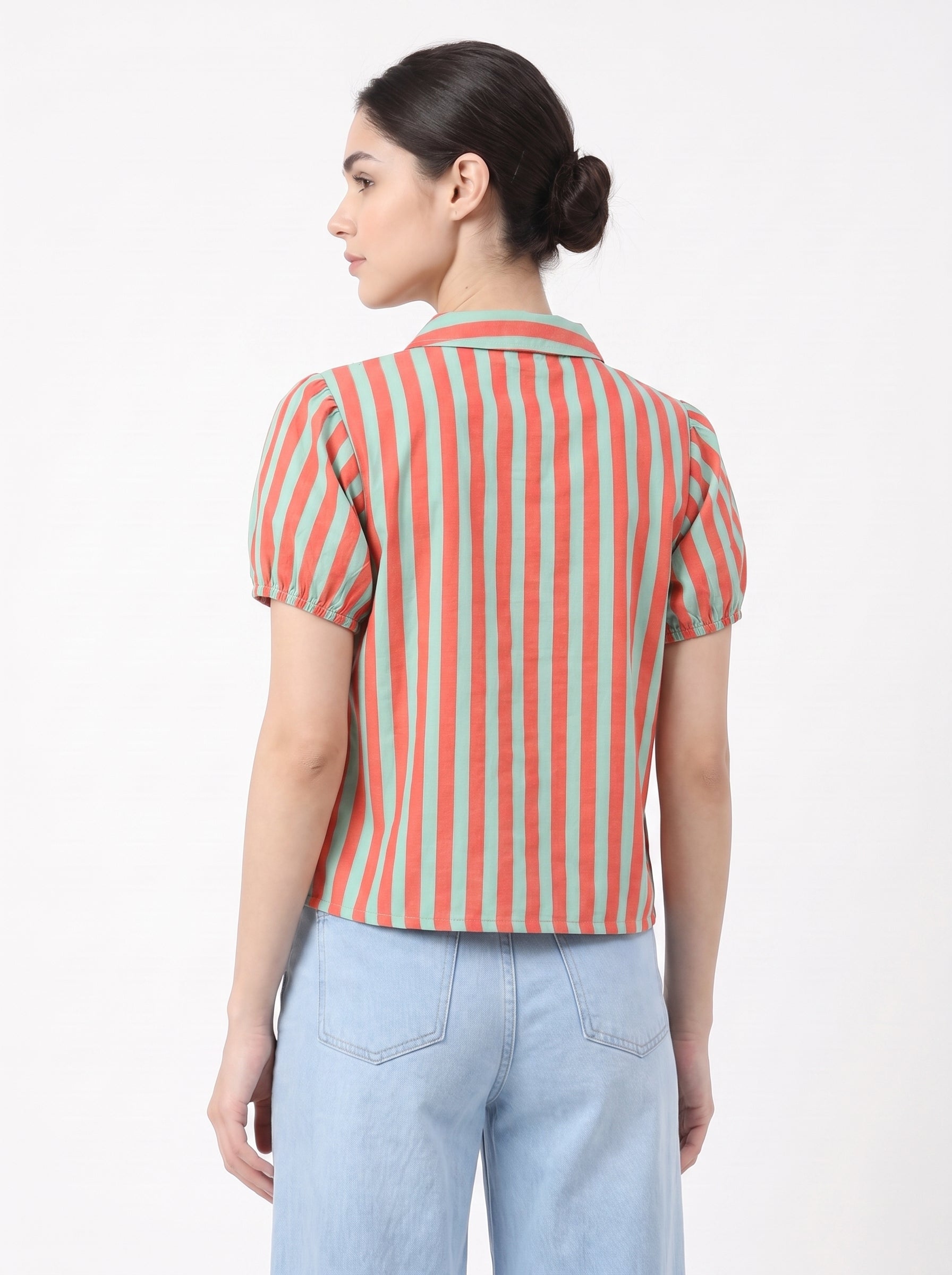 A woman shown from the back wearing a short-sleeve collared top with vertical coral and mint green stripes, paired with light blue jeans, against a plain white background.