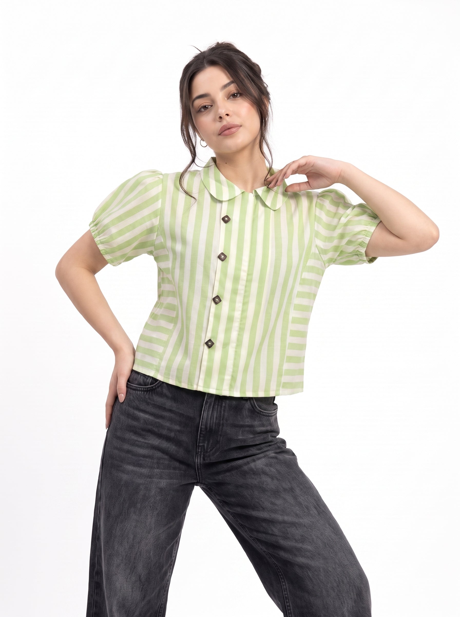 A woman modeling a light green and white vertically striped short-sleeve blouse with a Peter Pan collar and dark buttons, paired with dark gray jeans, against a plain white background.