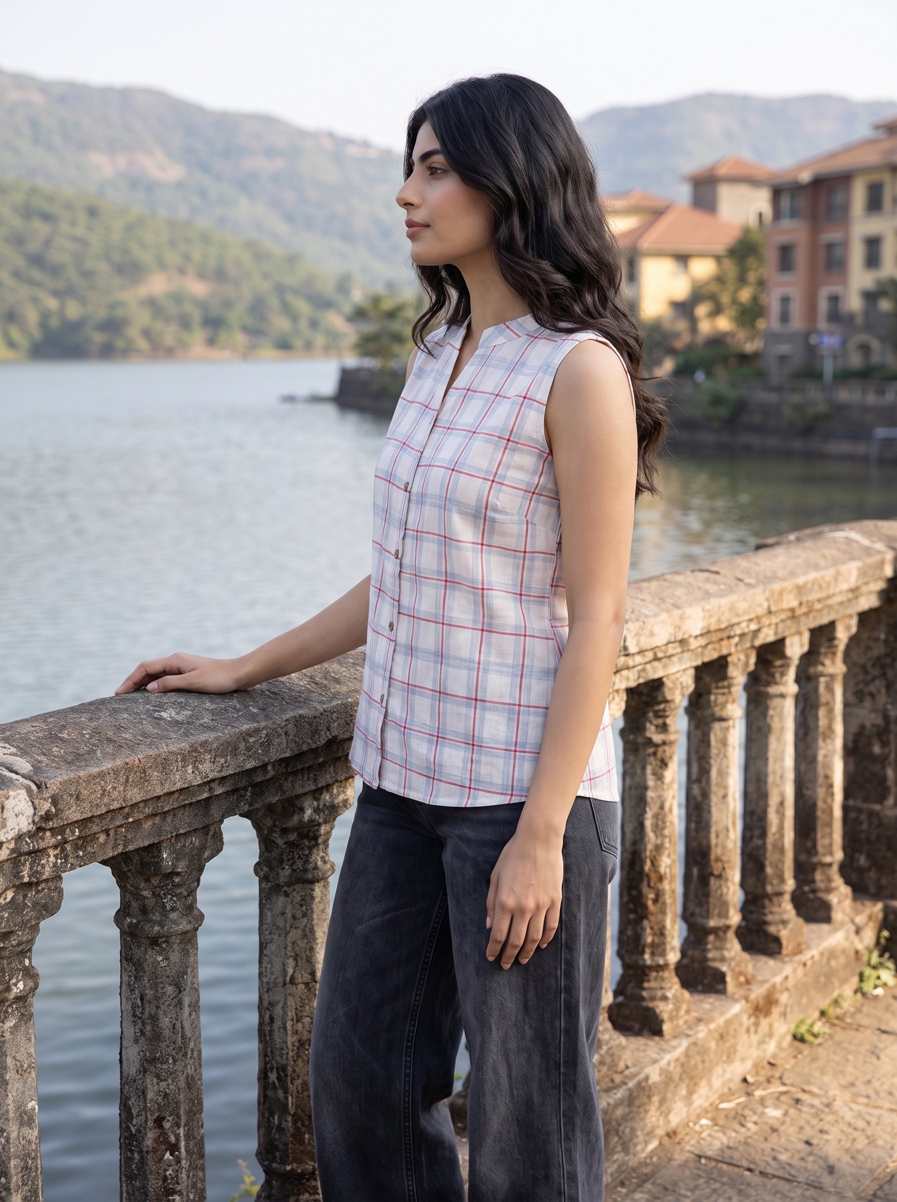 Add a clean and contemporary touch to your wardrobe with this soft blue and red checkered sleeveless top, featuring a neat split neckline and classic front button closure.