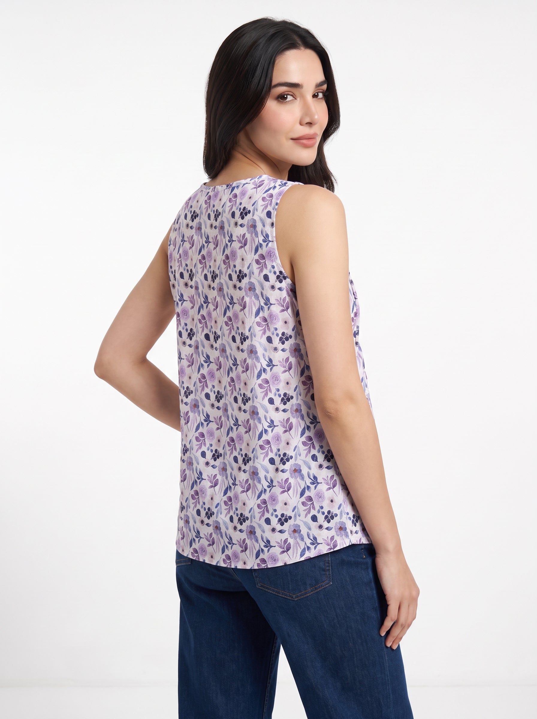 A sleeveless, scoop-neck top with a pleated texture and an all-over watercolor floral print in shades of purple, pink, and blue on a white background.