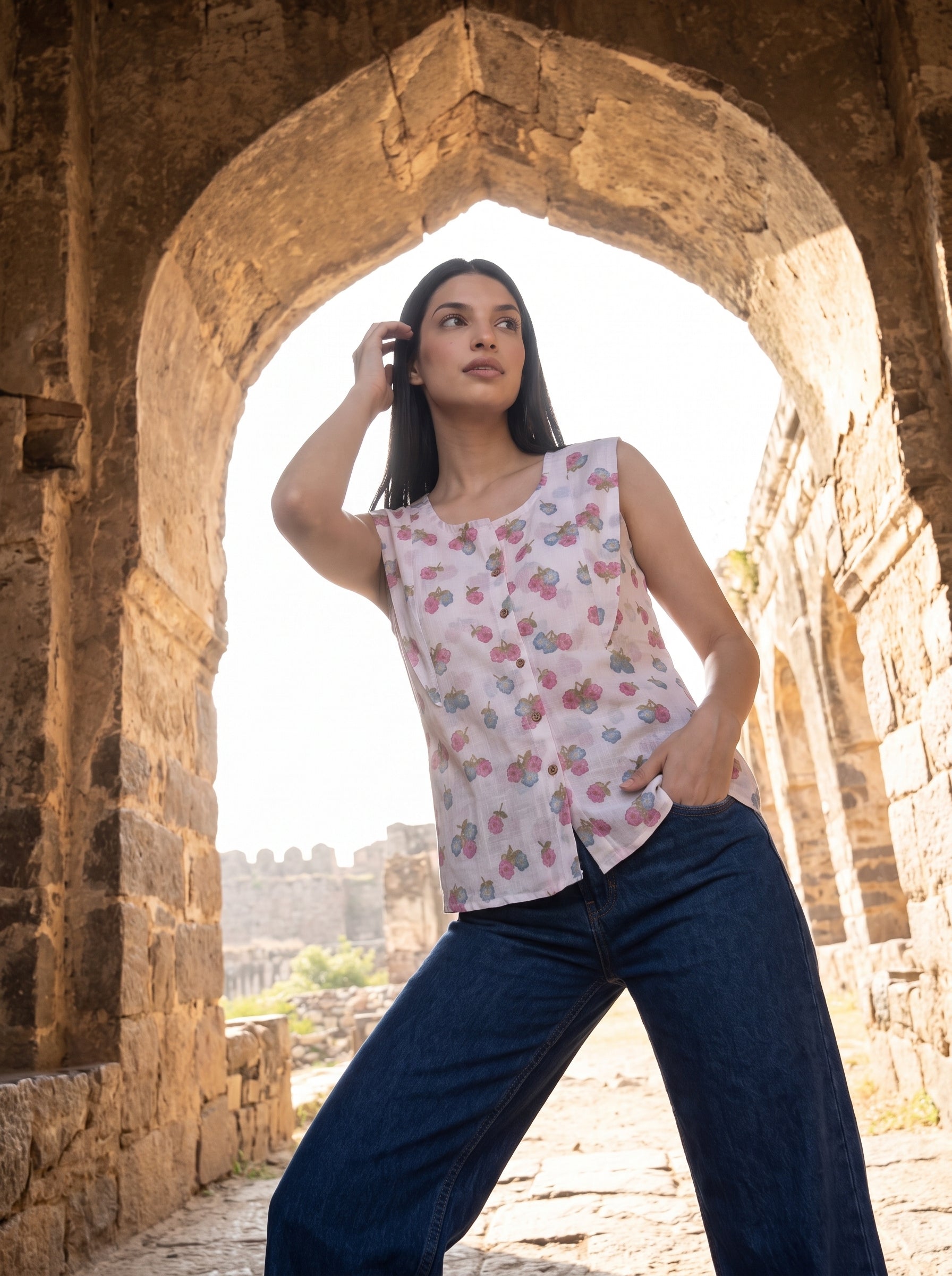 A fresh off-white sleeveless top featuring delicate pink and blue floral clusters for a soft feminine look. 