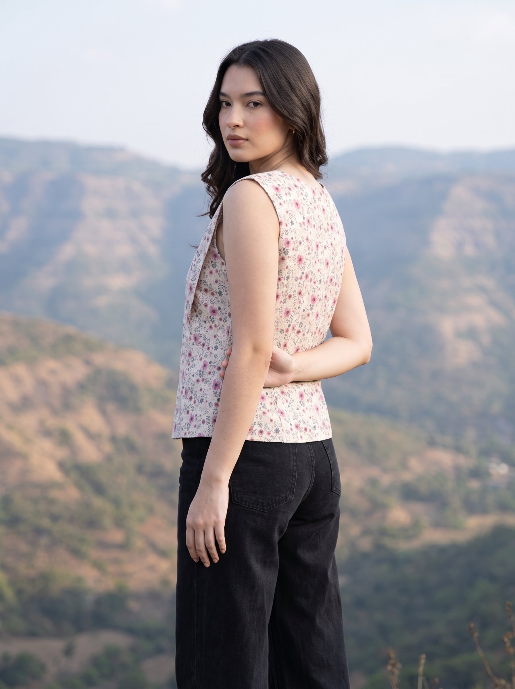 A charming Beige sleeveless top featuring delicate pink mini florals with subtle grey and green botanical accents for a soft feminine look.  