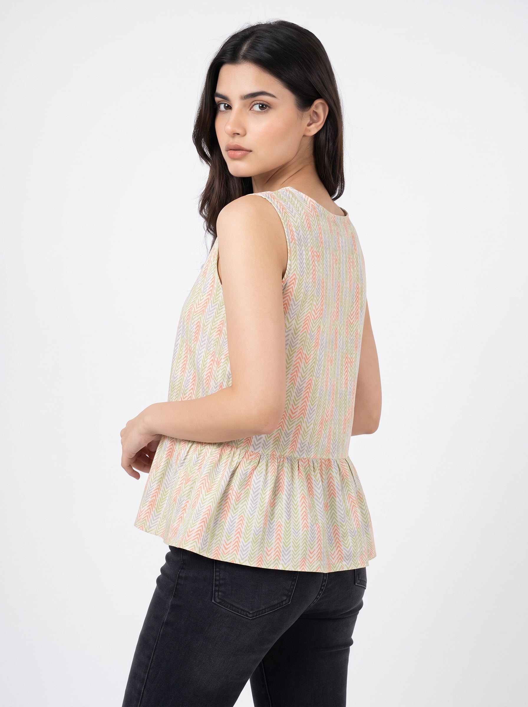 A fresh off-white sleeveless top featuring a soft pastel chevron print in peach, green, lavender, and yellow tones