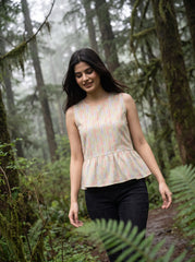 A fresh off-white sleeveless top featuring a soft pastel chevron print in peach, green, lavender, and yellow tones