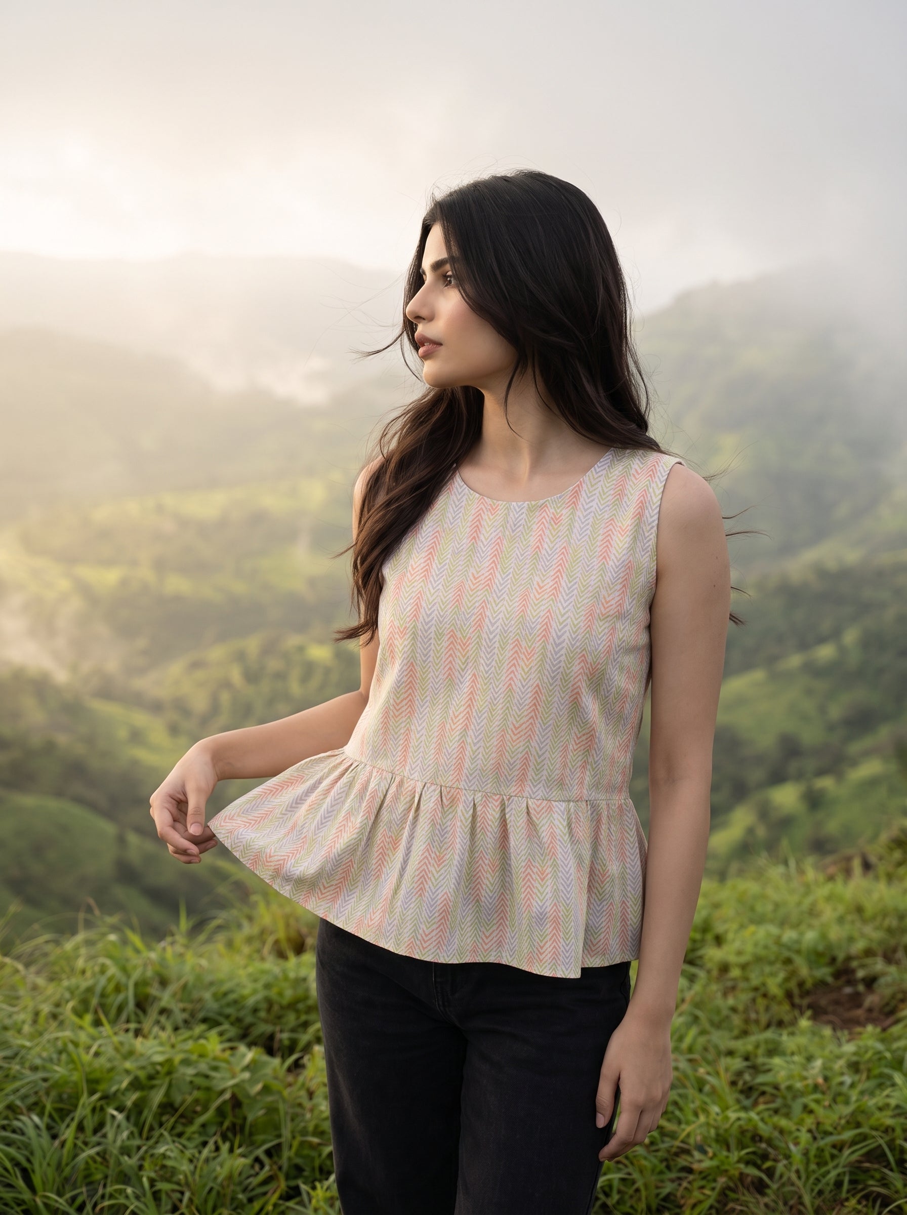 A fresh off-white sleeveless top featuring a soft pastel chevron print in peach, green, lavender, and yellow tones