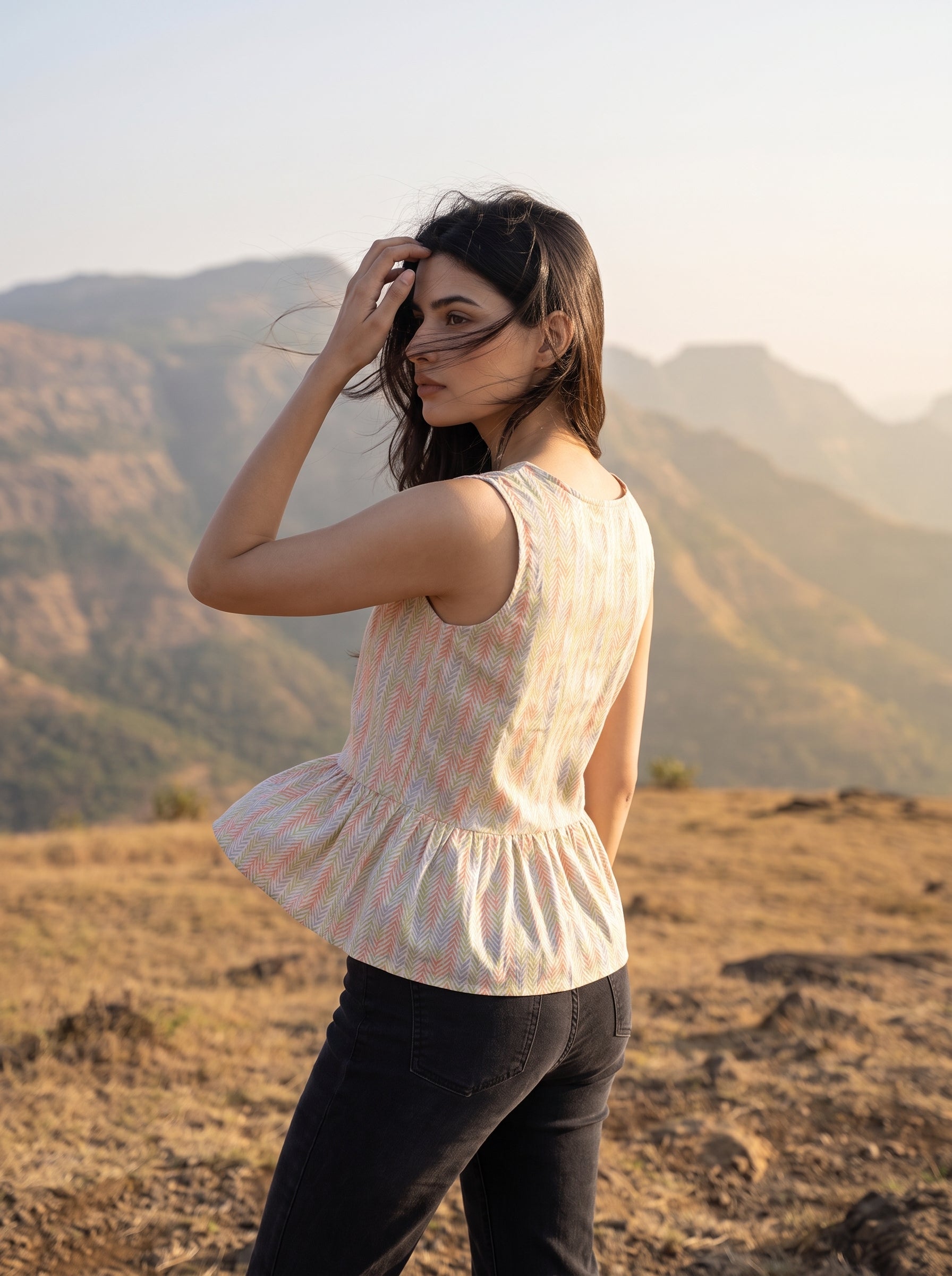 A fresh off-white sleeveless top featuring a soft pastel chevron print in peach, green, lavender, and yellow tones